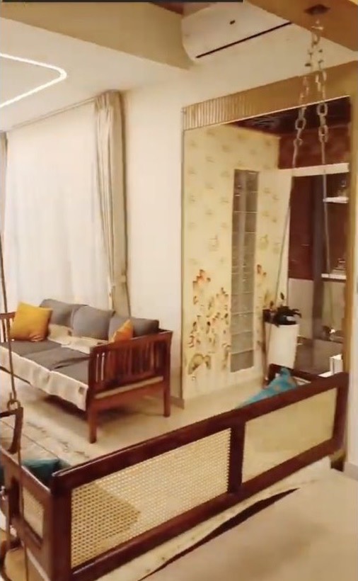 Completed Azven Breathe villa living room with a signature illustrated wall, custom cane furniture and a suspended swing